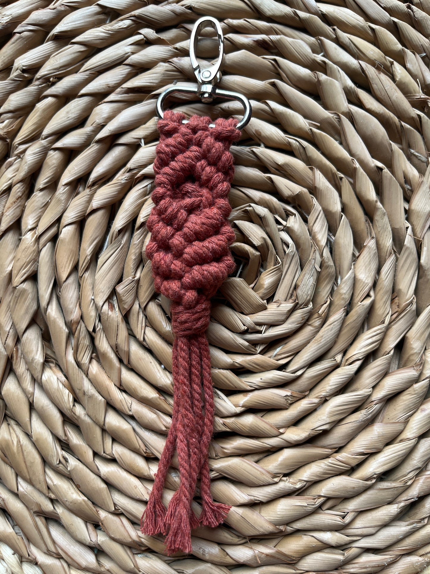 Red braided keychain on a woven mat