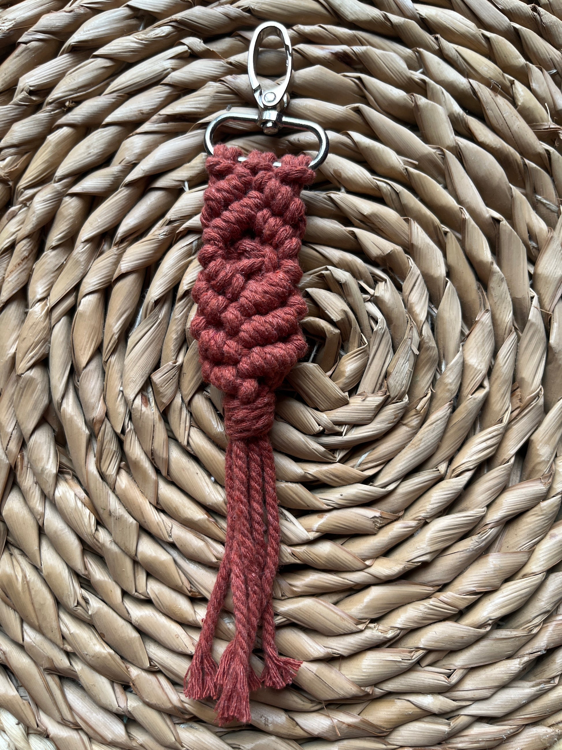 Red braided keychain on a woven mat