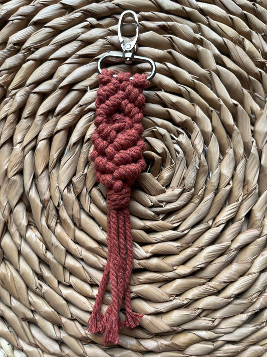 Red braided keychain on a woven mat