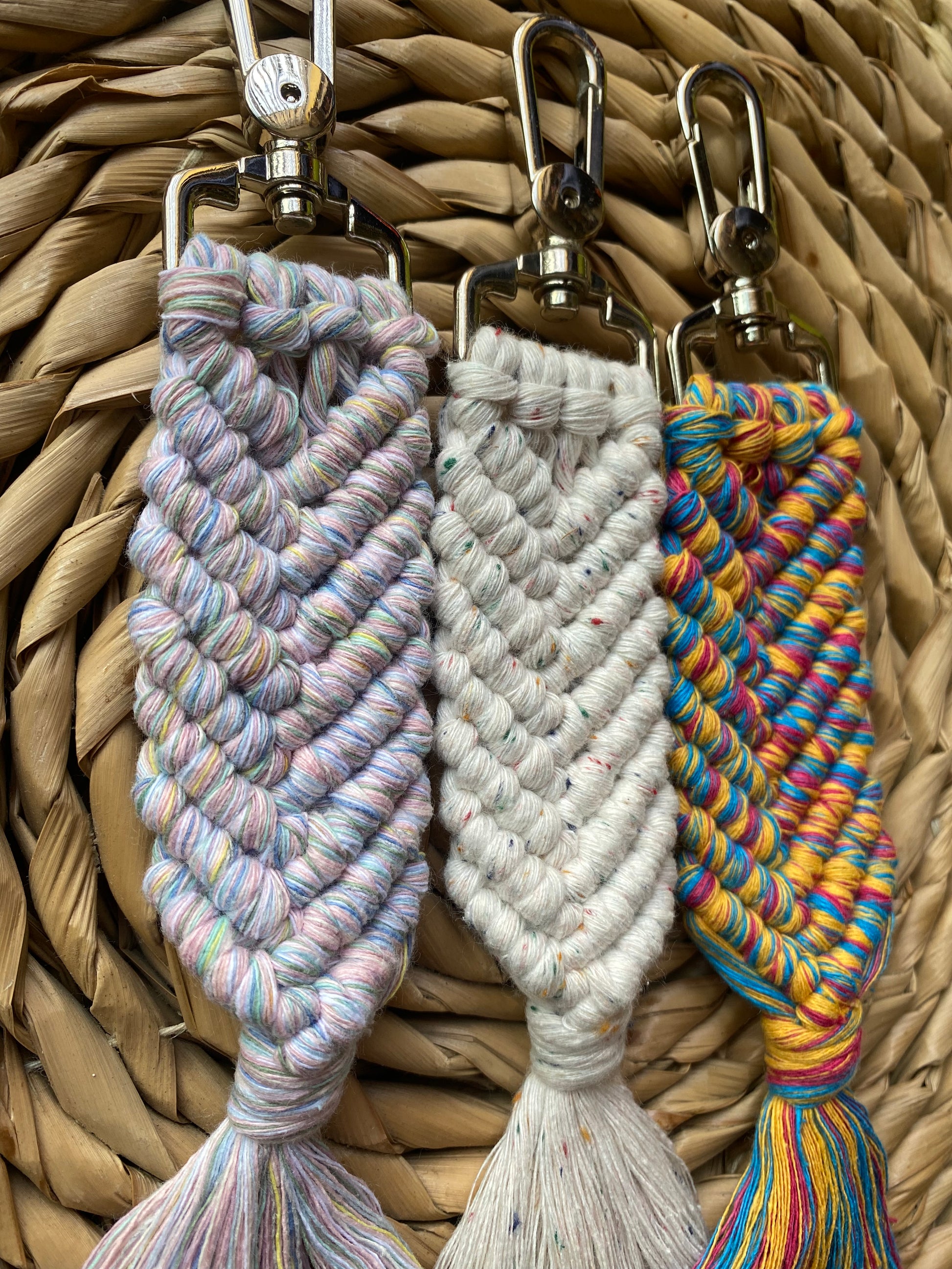 Three handmade macrame keyrings, knotted using recycled cotton, in the shape of a mermaids tail, and finished with a metal lobster clasp. 