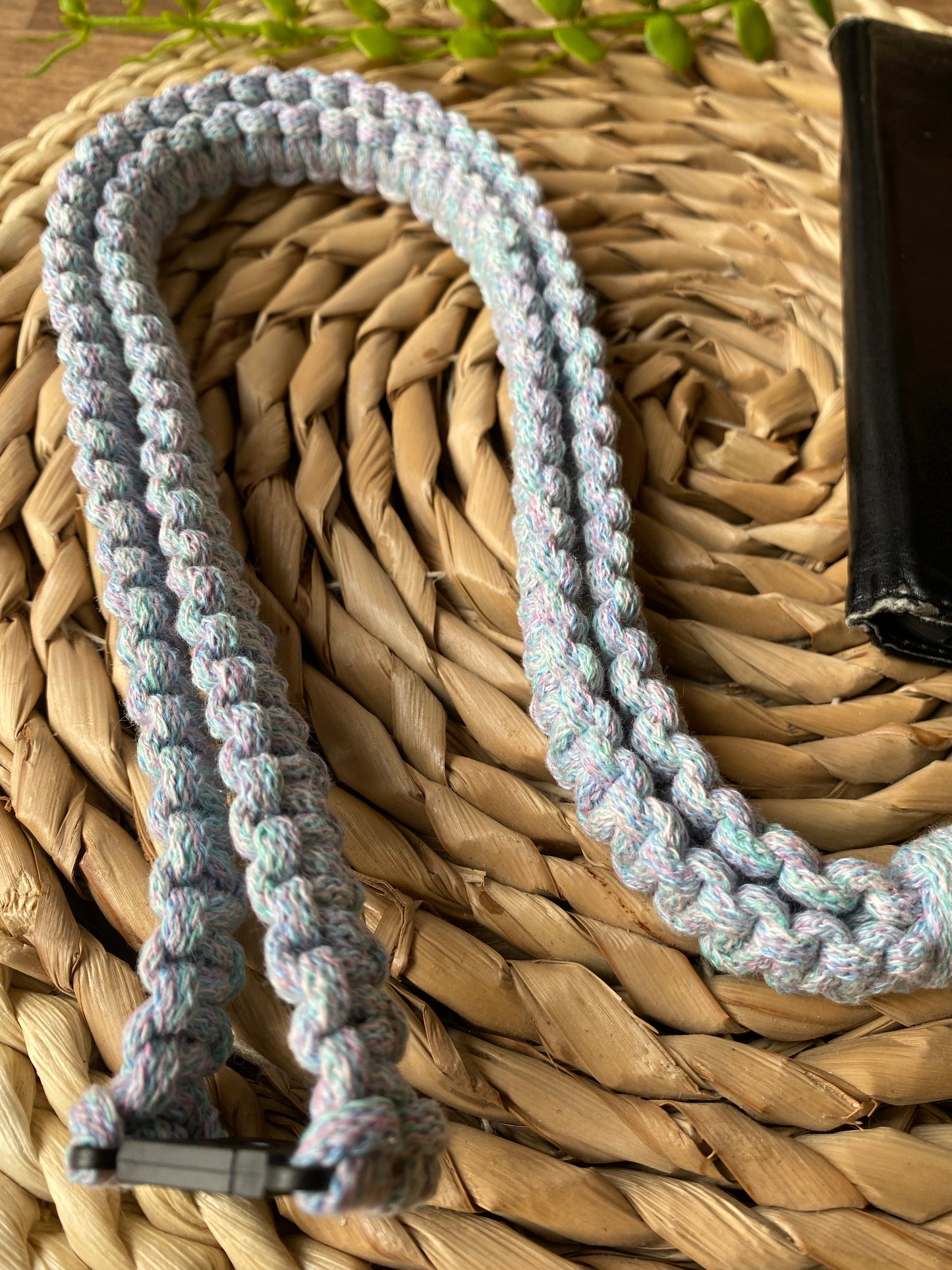 Close up of a macrame phone lanyard made with pastel coloured yarn and a safety break clasp.