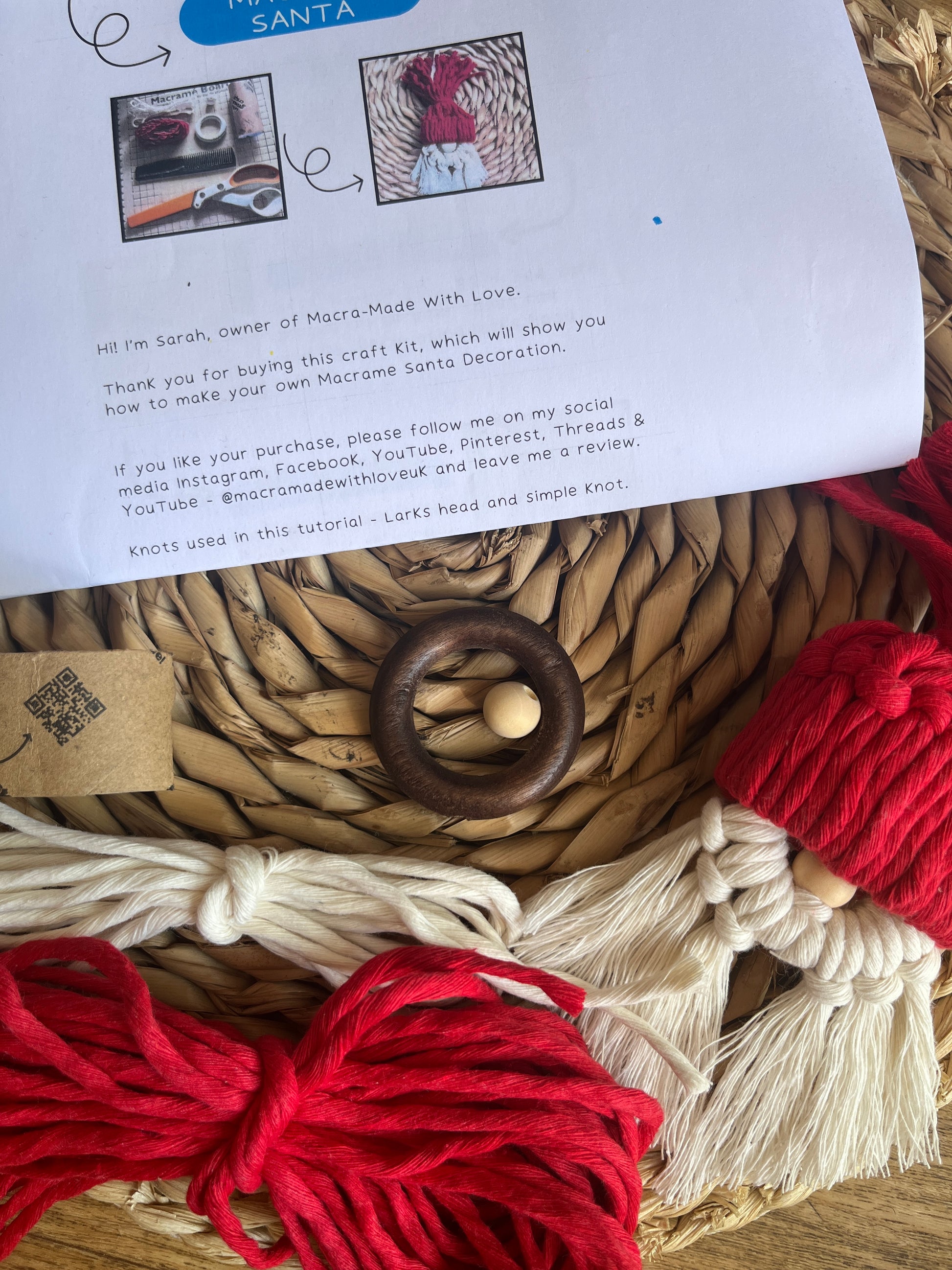 Macrame project with red and white yarn on a woven surface