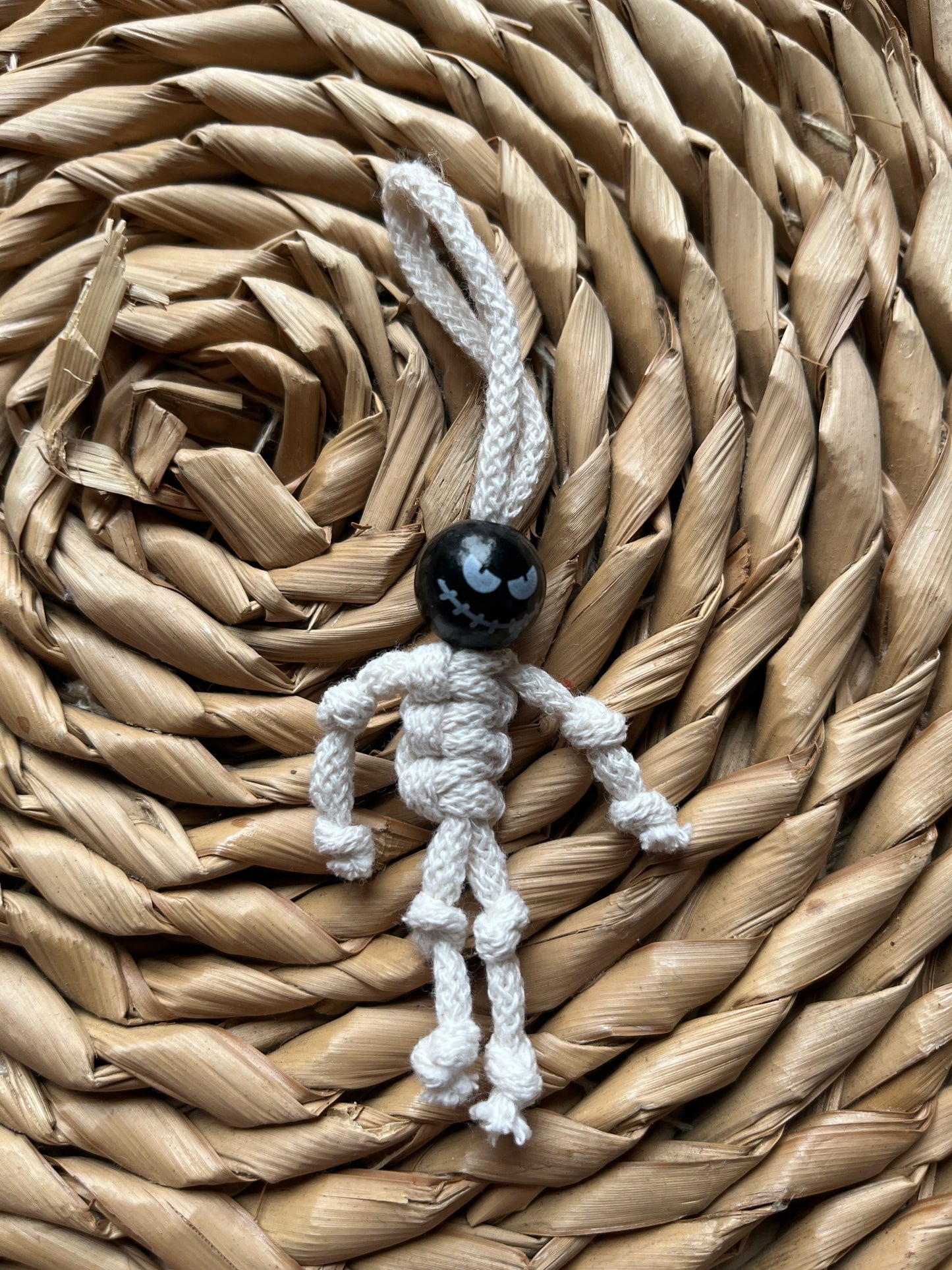 Macrame skeleton made with natural yarn and a black bead