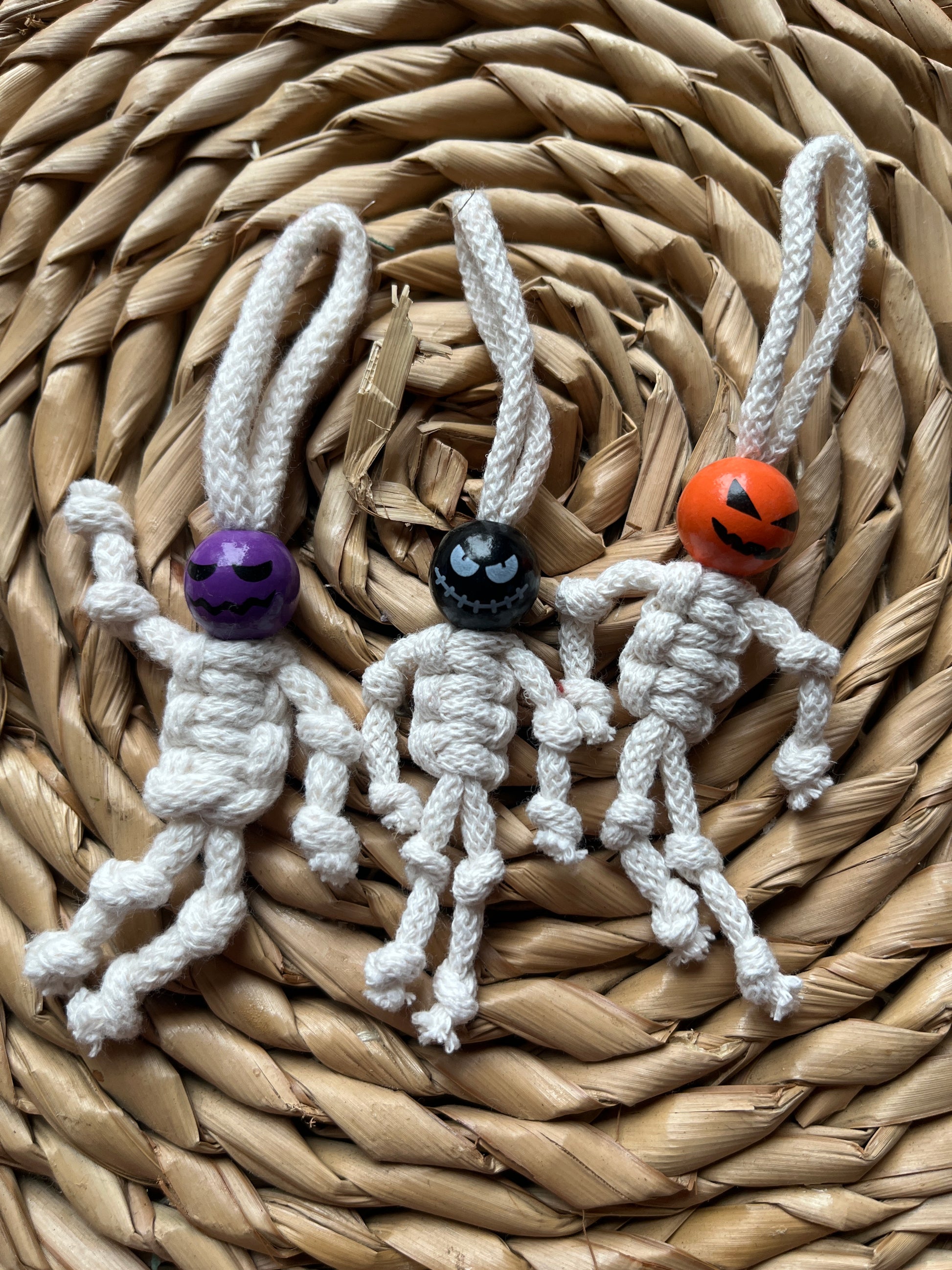 3 macrame skeletons made with natural yarn and colourful beaded faces 