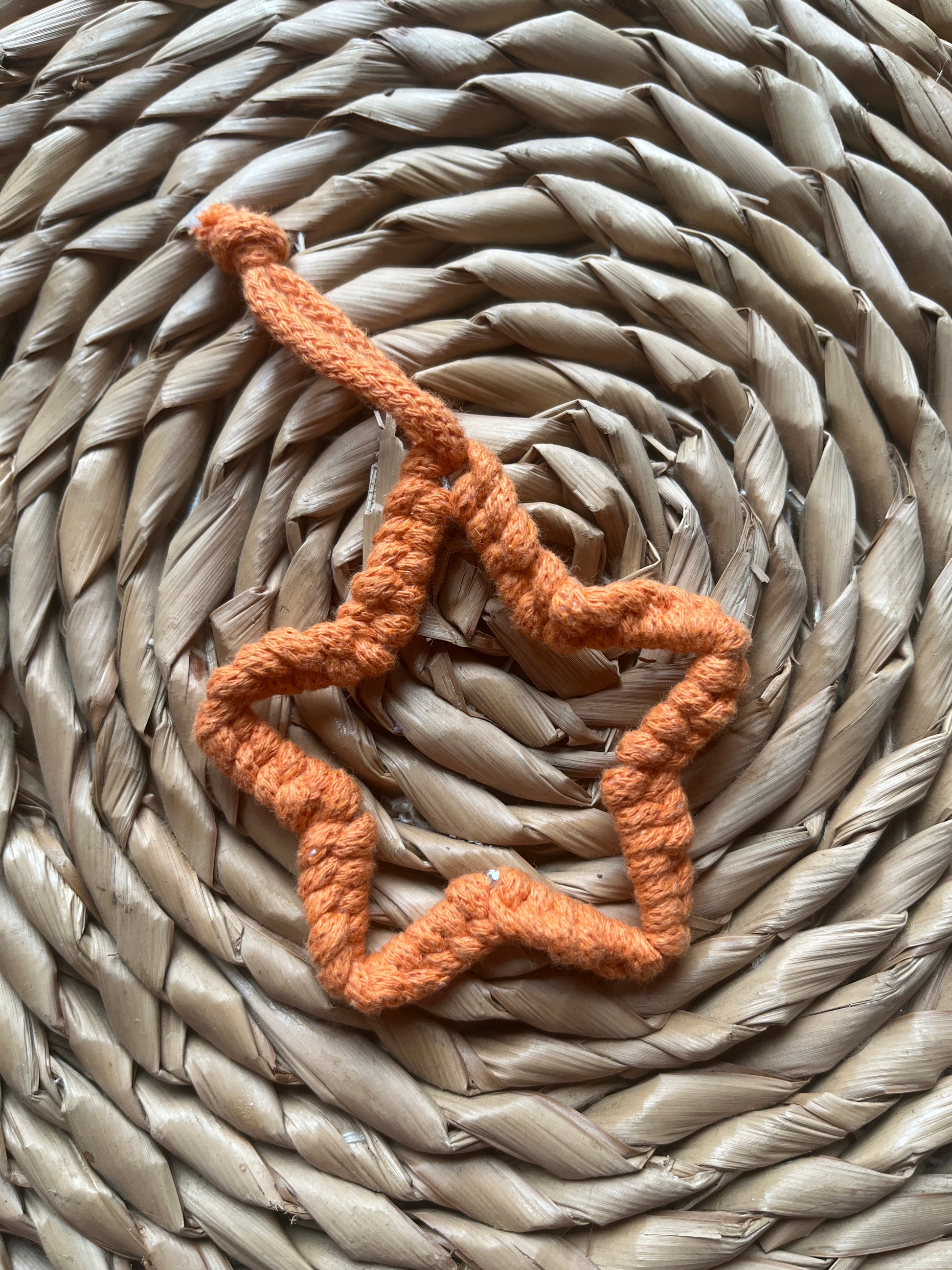 Small orange star decoration on a woven mat