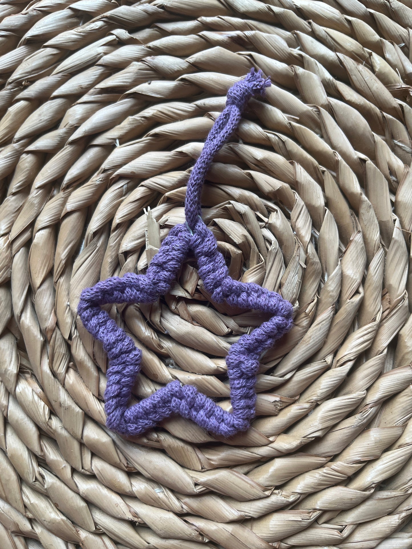 Small purple star decoration on a woven mat