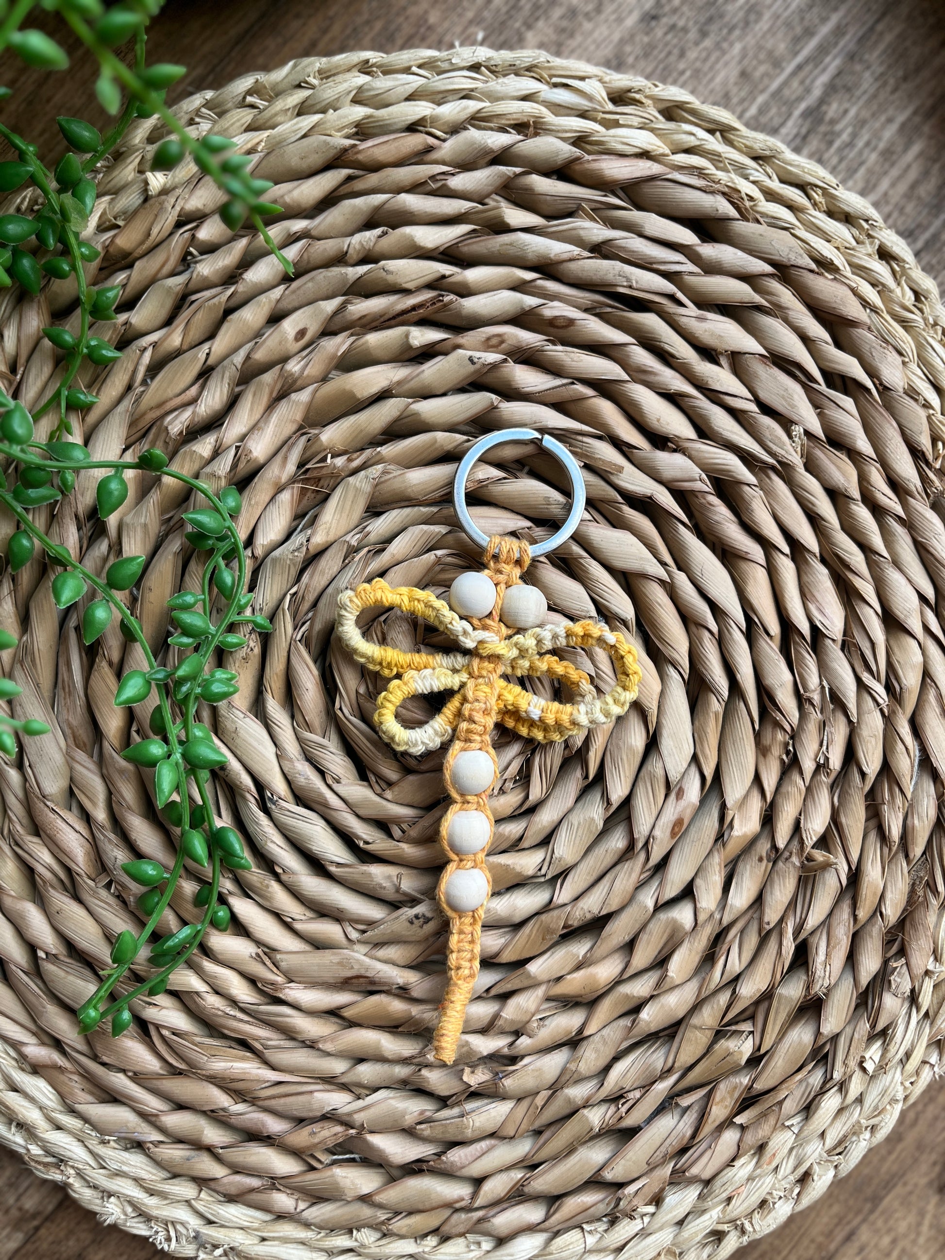 Handmade macrame dragonfly keyring or bag charm, made using shades of yellow recycled cotton, on a metal split ring, with small wooden beads. 