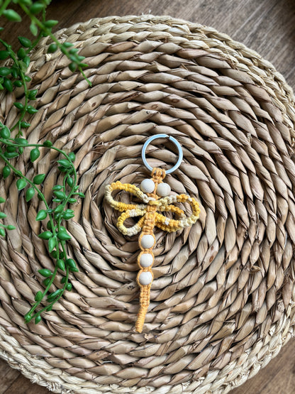 Handmade macrame dragonfly keyring or bag charm, made using shades of yellow recycled cotton, on a metal split ring, with small wooden beads. 
