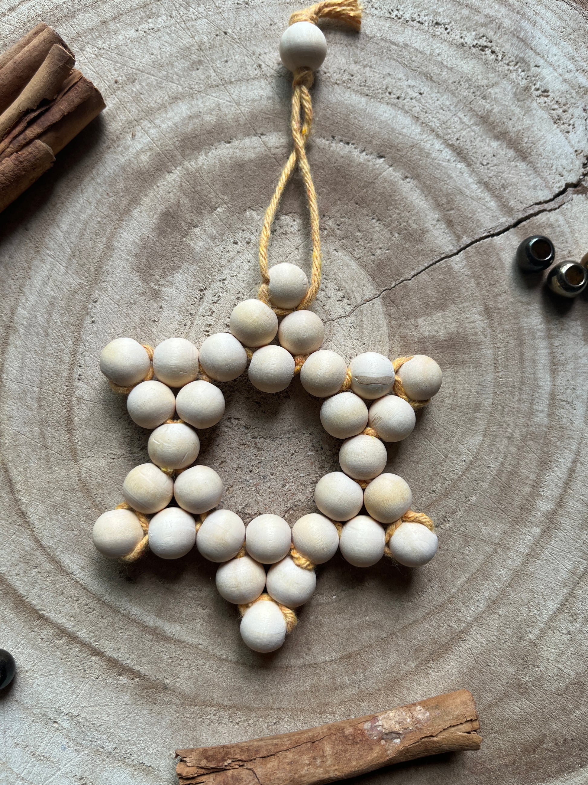Decorative star made of wooden beads on a rustic wooden surface