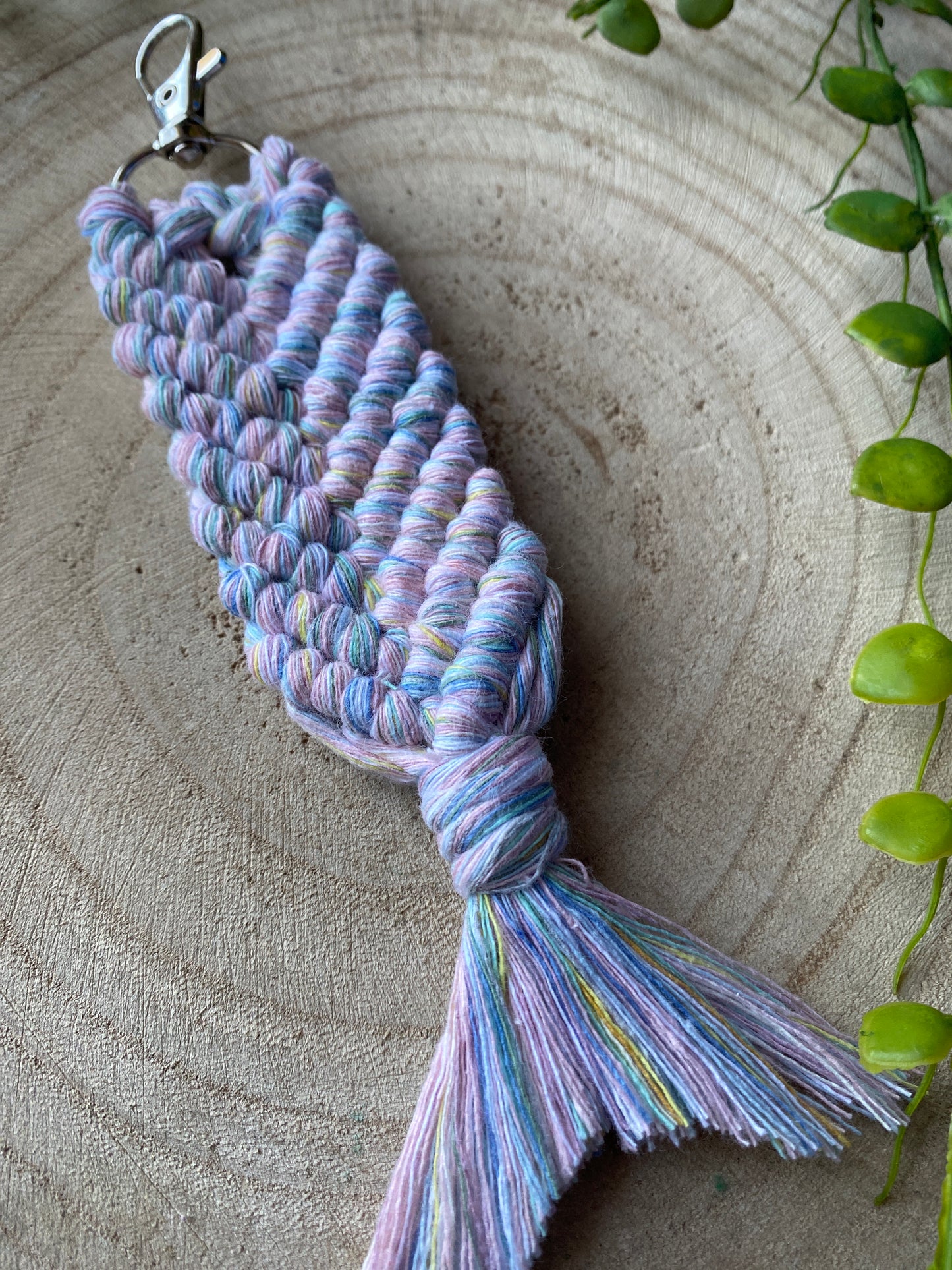 A handmade macrame keyring, knotted in the shape of a mermaid tail, made with soft pastel coloured recycled cotton and finished with a metal lobster clasp. 